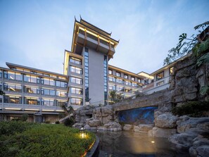 A modern hotel with multiple floors, a stone bridge, and a water feature. - Holiday Inn Guilin Qixing by IHG (Guilin)