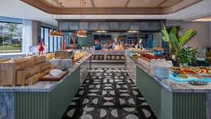 Una cocina moderna con una isla central, techo de madera y ventanas amplias.