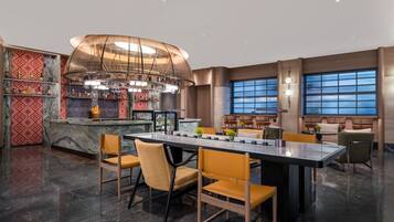 A modern bar area with a curved ceiling, marble countertops, and a variety of bottles and glasses.