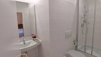 Ein Badezimmer mit Waschbecken, Toilette und einer Duschkabine.