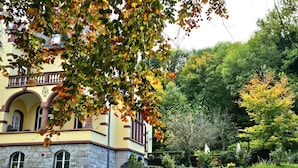 A historic building with a stone facade, arched windows, and a well-maintained garden with a stone pathway leading to the entrance. - Hotel Erbprinzenpalais (Wernigerode)
