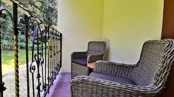 A balcony with wicker furniture and a metal railing.