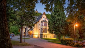 A historic building with a prominent tower, a well-maintained lawn, and a paved driveway leading to the entrance. - Hotel Erbprinzenpalais (Wernigerode)
