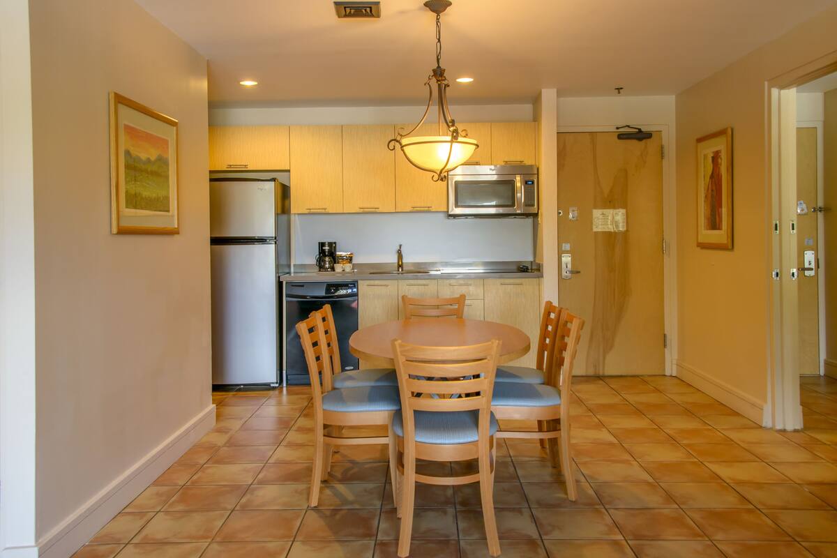 Cocina compacta con comedor, equipada con refrigerador, microondas y lavavajillas.