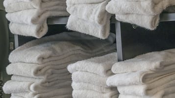 A stack of white towels on a shelf.