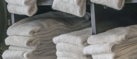 A stack of white towels on a shelf.