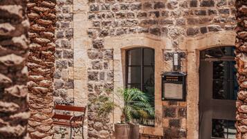 Edificio de piedra con un banco y plantas en macetas.