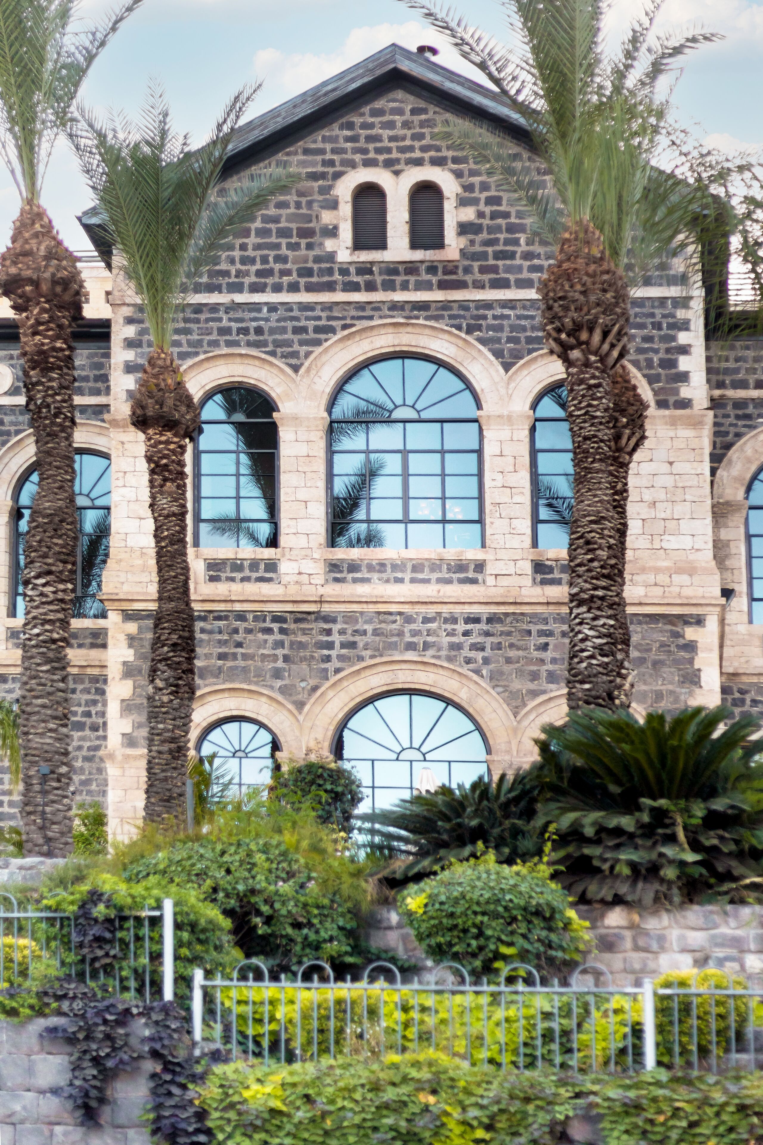 Un edificio de piedra con ventanas de arco y una torre central.