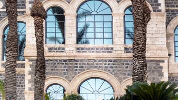 Un edificio de piedra con ventanas de arco y una torre central.