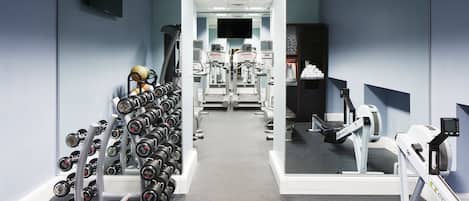 A gym with exercise equipment, including dumbbells, treadmills, and stationary bikes.