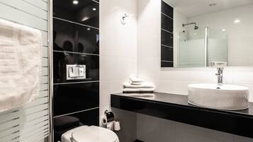 Un baño moderno con inodoro, lavamanos y espejo.