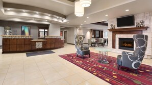 A spacious lobby with a reception desk, seating area, and a fireplace.