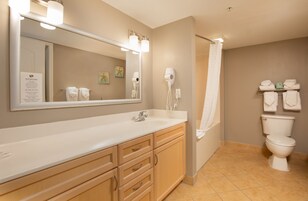 A bathroom with a sink, mirror, towel rack, and toilet.