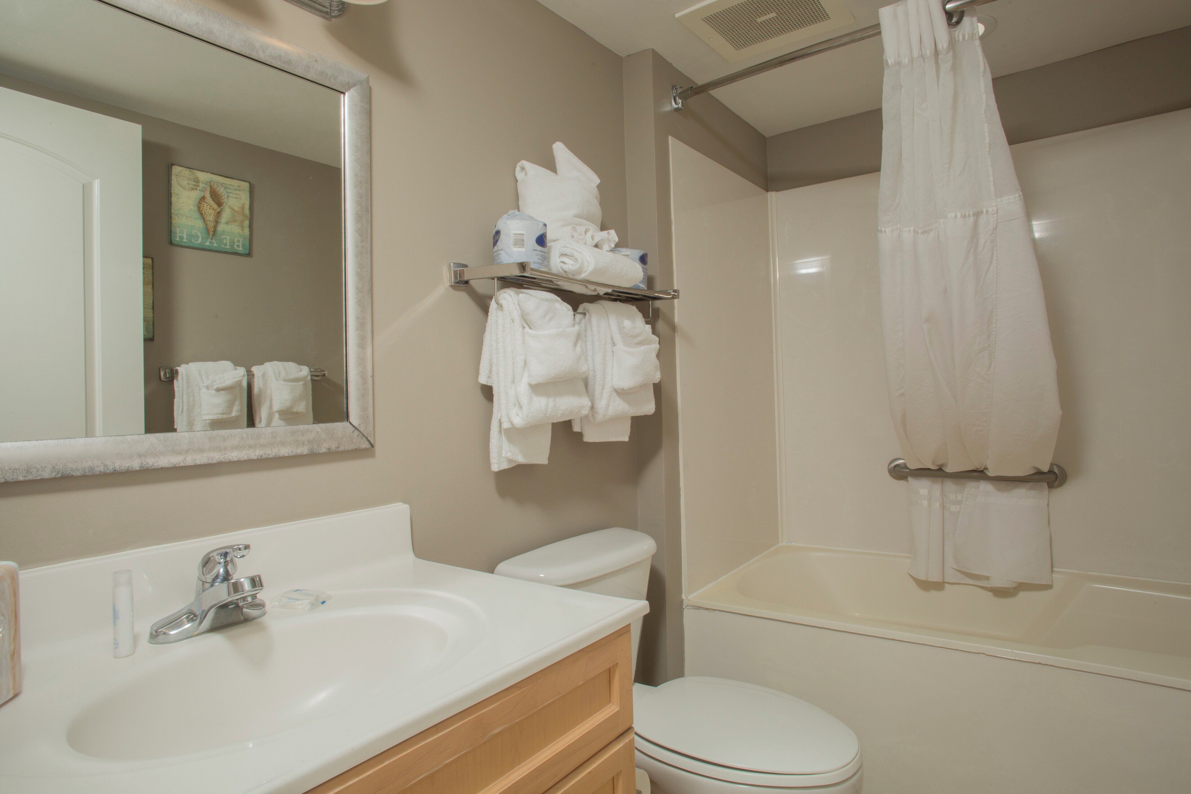 Un baño con lavamanos, inodoro y cortina de ducha.