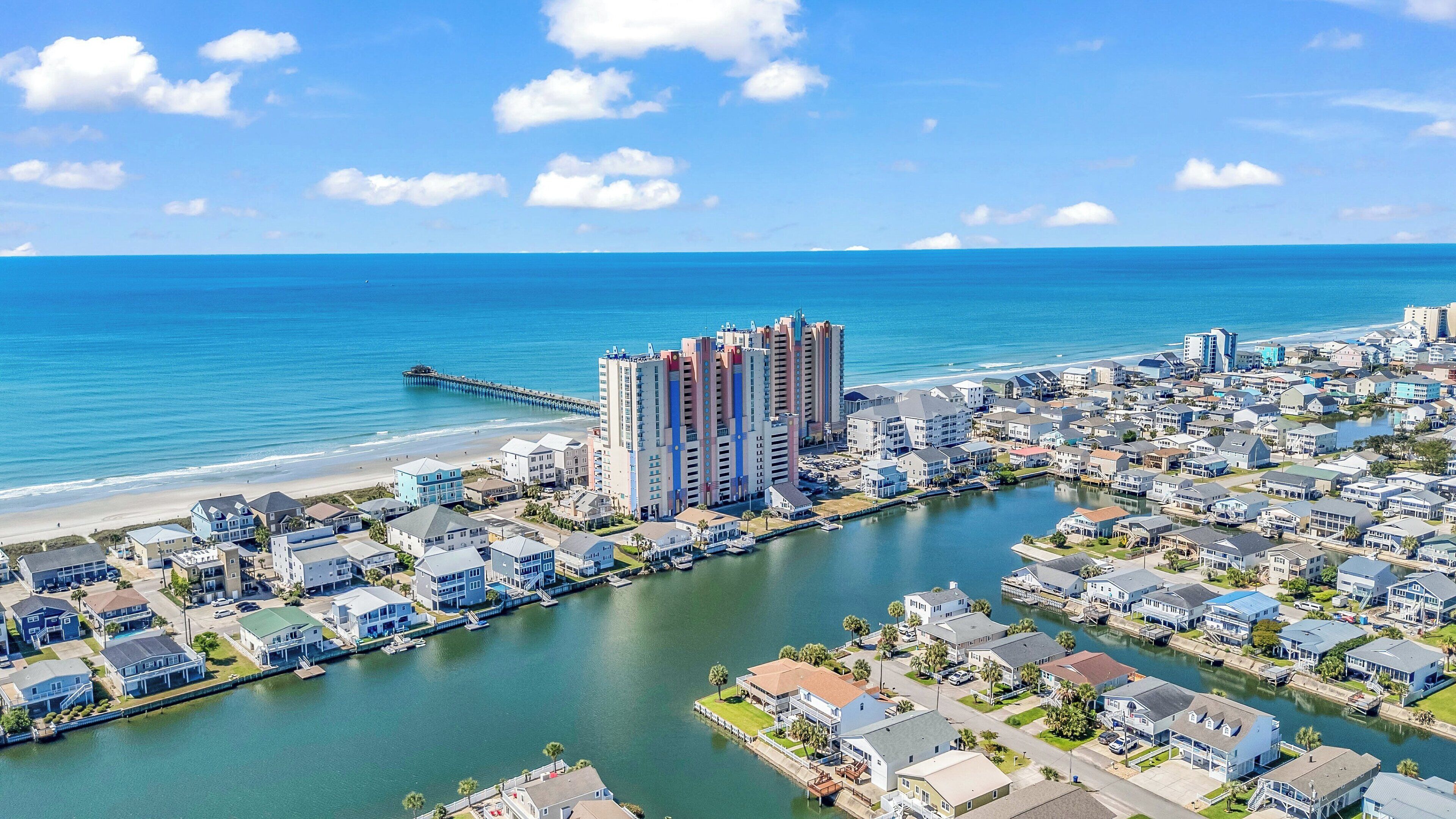 Una zona residencial costera con puerto deportivo, playa y edificios de gran altura.