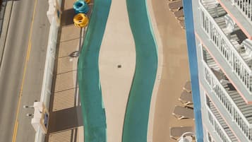 Hotel features a unique wave-shaped pool surrounded by lounge chairs and umbrellas.