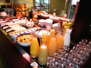 Un bufé con diversas opciones de comida y bebidas.