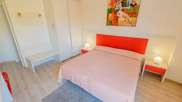 Una camera da letto con un letto, comodini, una panca e un quadro appeso al muro.
