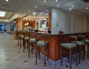 A spacious kitchen area with a central island, bar stools, and a large window providing natural light. - Hilton Garden Inn West Monroe (West Monroe)