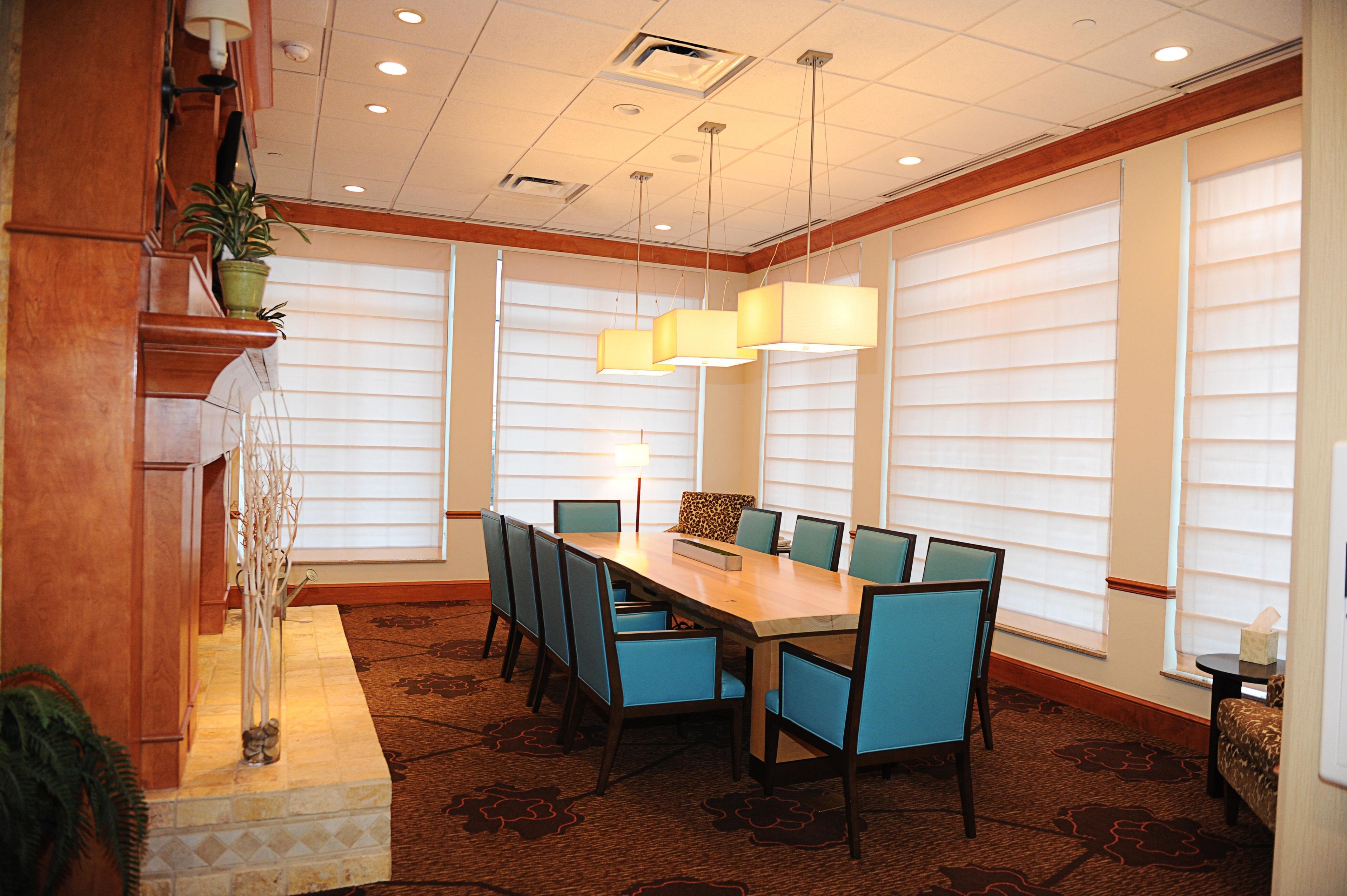 A conference room with a long table, chairs, and a chandelier.