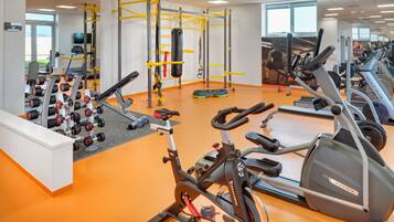 A gym with various exercise equipment, including treadmills, stationary bikes, and weight machines.