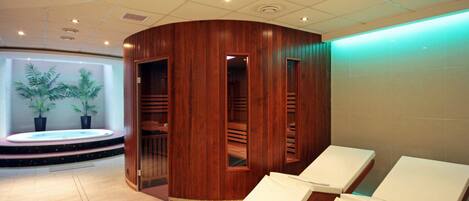 Un cuarto de spa con paneles de madera, un jacuzzi y dos sillones de descanso.
