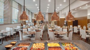 A buffet area with multiple food stations and hanging copper pendant lights. - Avanti Hotel Brno (Brno)