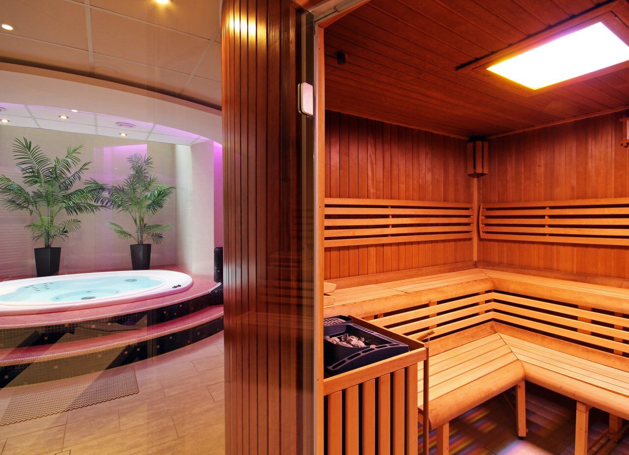 Een sauna met houten banken en een whirlpool.