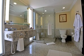 A modern bathroom with a glass-enclosed shower, a toilet, and a vanity with a granite countertop.