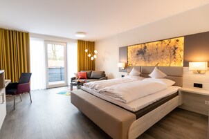 Una habitación de hotel moderna con una cama grande, un escritorio, una silla y un sofá.
