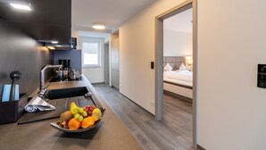 A modern kitchen with a fruit bowl, a sink, and a breakfast bar. - Hotel Leugermann (Ibbenbueren)