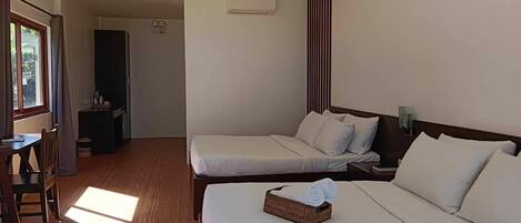 A hotel room with two beds, a desk, and a wardrobe.