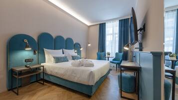 A modern hotel room with a large bed, bedside tables, a desk, and a chair.