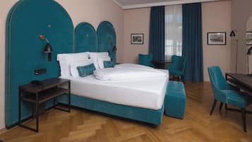 Une chambre d’hôtel avec un grand lit, un bureau, une chaise et une petite table.