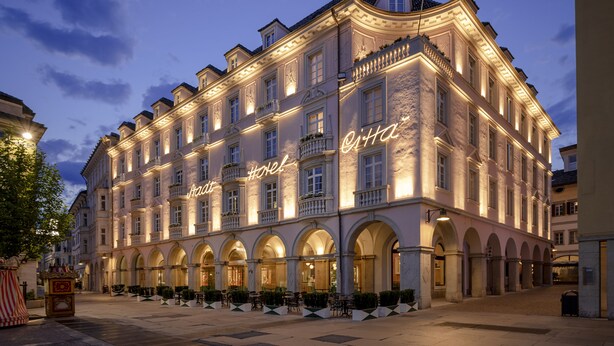 A historic hotel with arched windows and a well-lit facade. - Stadt Hotel Citta (Bolzano)