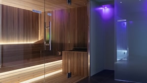 A modern interior with a wooden reception desk, a glass partition, and a corridor with purple lighting. - Stadt Hotel Citta (Bolzano)