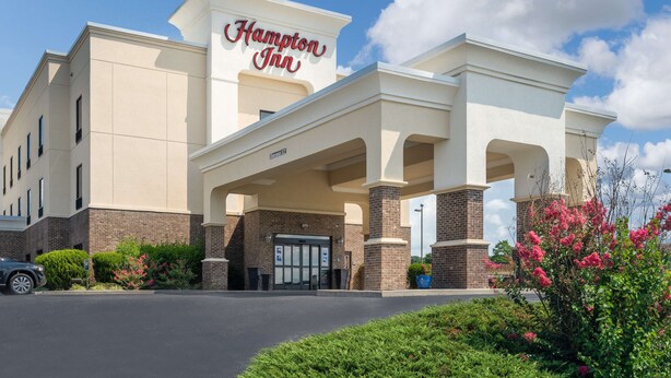 A Hampton Inn hotel with a classic facade, a central entrance, and a parking lot.