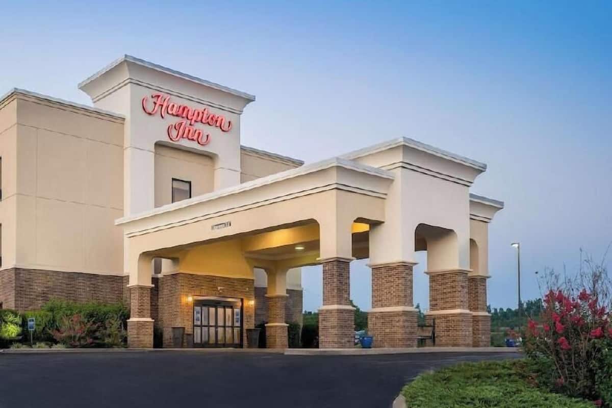 A Hampton Inn hotel with a covered entrance and brick pillars.