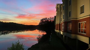 A building with a reflective water body in the foreground, likely a hotel or residential complex.