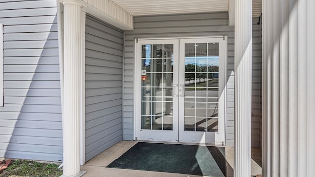 A house entrance with a glass door, a covered porch, and a visible driveway. - Motel 6 McAlester, OK (Krebs)