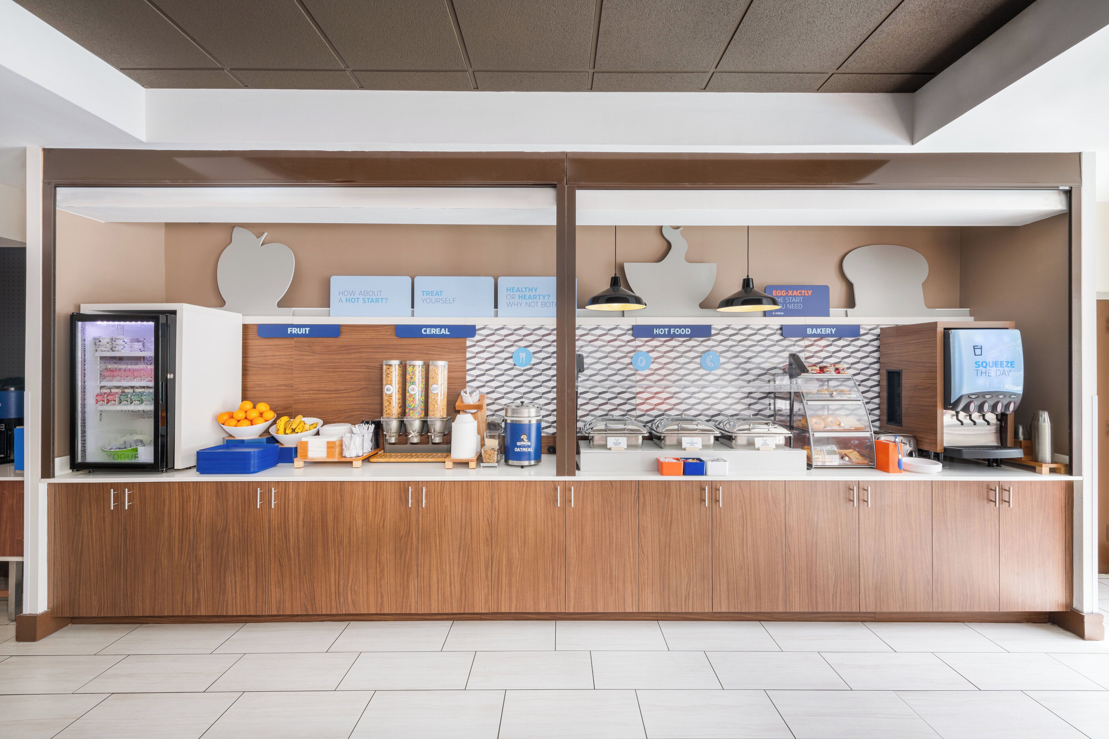 Zona de buffet lliure per esmorzar, amb seccions identificades per fruita, cereals, plats calents i fleixos.