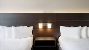 A hotel room with two beds, a nightstand, and a wall-mounted light fixture. - Holiday Inn Express & Suites Spring Hill by IHG (Spring Hill)