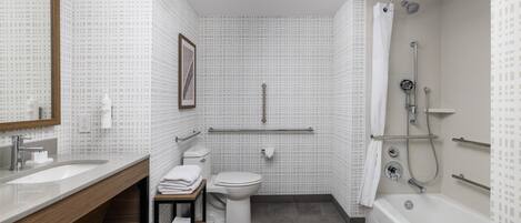 A modern bathroom with a large sink, toilet, and bathtub.