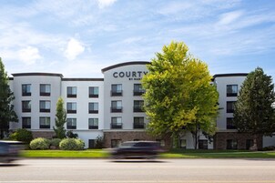 Un hotel de varios pisos con un diseño moderno, que destaca un cartel que dice "COURTY BY MARGOT".