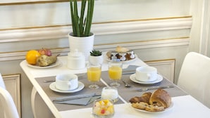 A breakfast table with a variety of food items, including fruits, pastries, and beverages. - Hôtel De France (Aix-en-Provence)