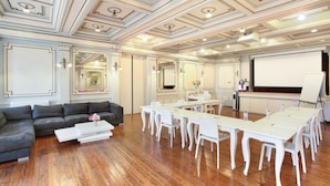 A conference room with a white table and chairs, a sofa, and a projector screen. - Hôtel De France (Aix-en-Provence)