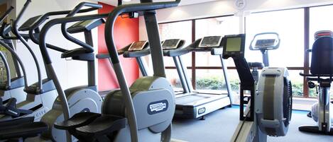 Een sportschool met loopbanden, elliptische trainers en krachtapparaten.