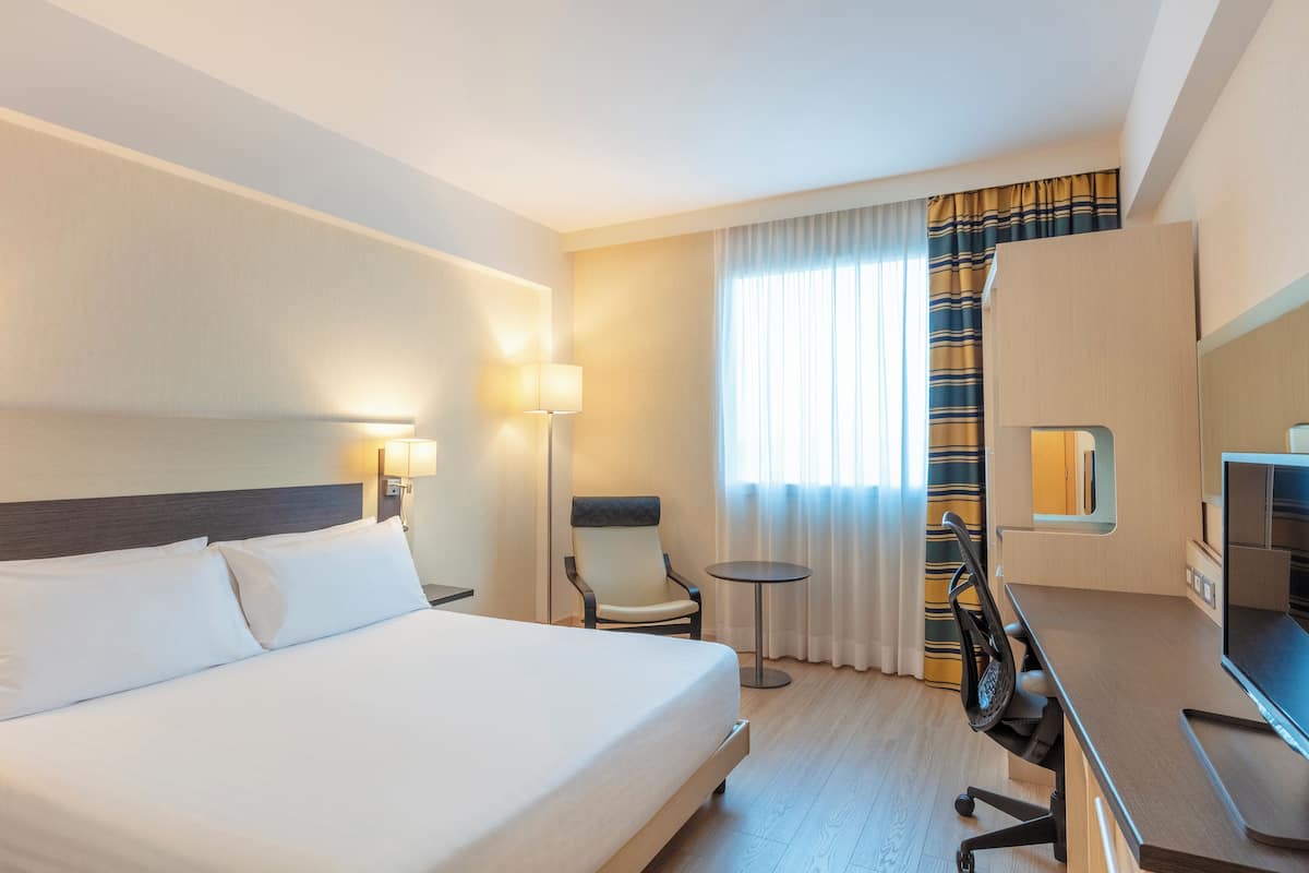 غرفة - سرير ملكي | أسرّة سليكت كومفورت وخزنة داخل الغرفة ومكتب وستائر تعتيم