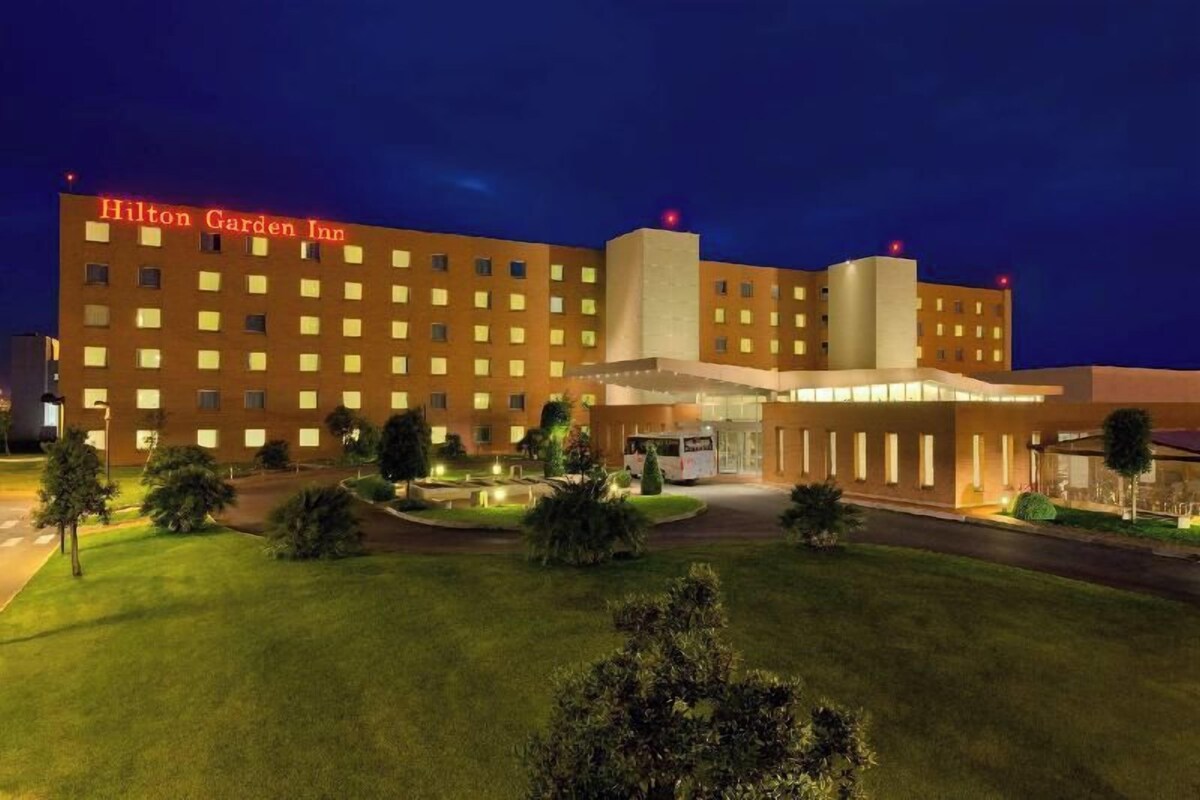 A Hilton Garden Inn with a modern design, a well-maintained lawn, and a clear entrance.
