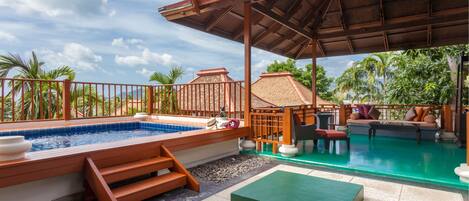 A covered outdoor area with a swimming pool, wooden deck, and lounge seating.